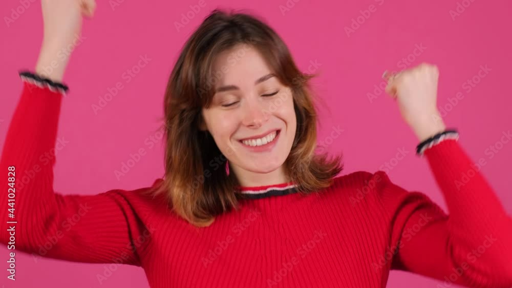 Close up of an young handsome woman standing over pink background celebrating surprised and amazed for success with arms raised and open eyes. Winner concept. Close up of an young handsome woman standing over pink background celebrating surprised and amazed for success with arms raised and open eyes. Winner concept.