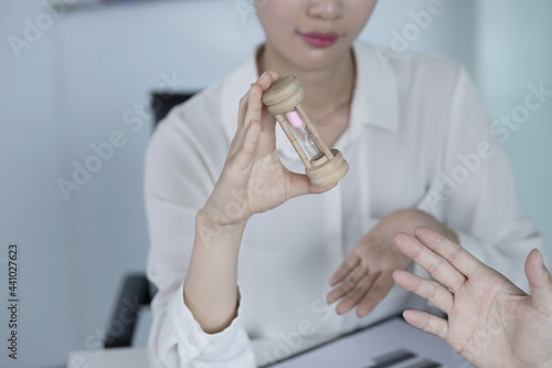 Businesswoman holding hourglass in meeting photo