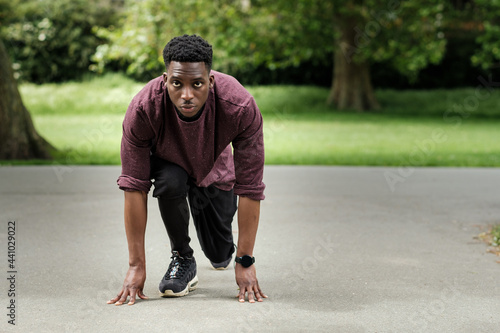 Fit young black man stretching in a park.