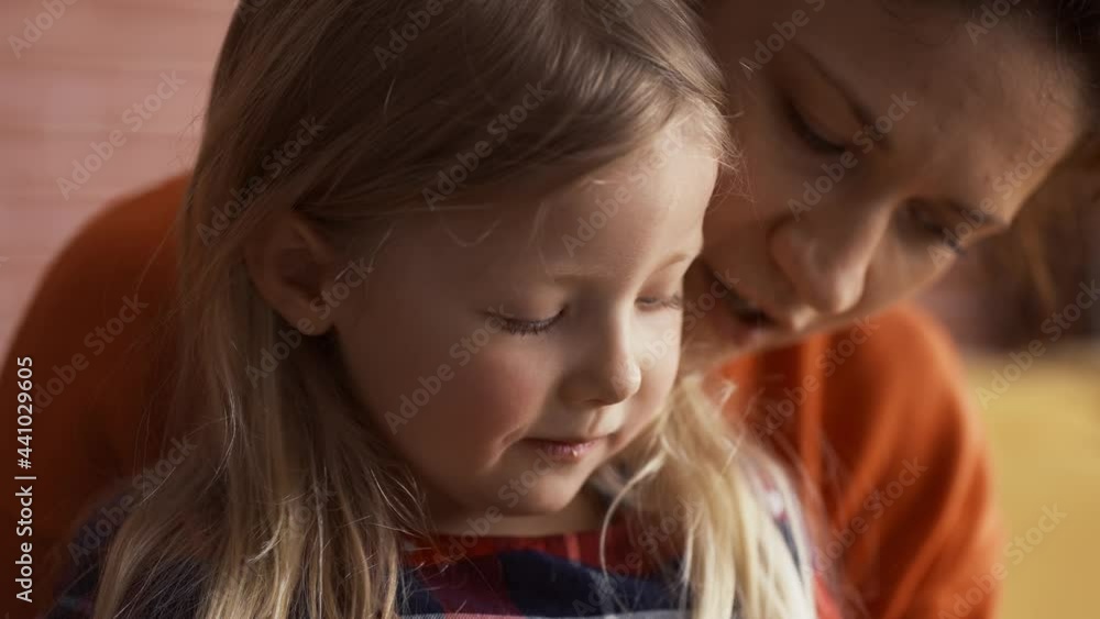 Portrait of a little girl eating biscuits at home with mom