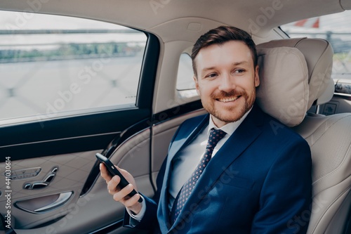 Corporate executive in elegant expensive tuxedo rides in luxury car © VK Studio