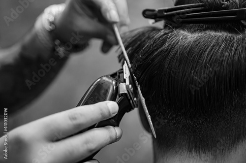 Hairdresser cutting a client's hair soft focus image.