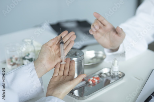 Doctor holding syringe in meeting