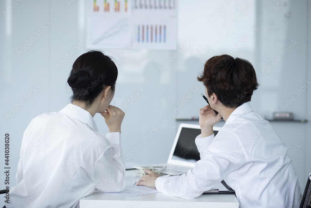 Business people looking at chart on board Business people looking at chart on board