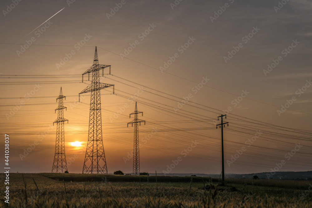Strommasten einer Überlandleitung bei Sonnenuntergang