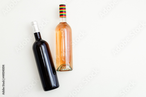 Rose wine bottle and red wine bottle . Minimalistic wine composition top view on white background. Two bottles of Wine brand mockup. Flat lay with copy space.