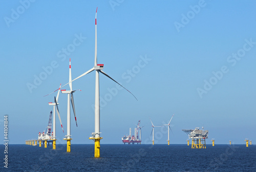 Industrial stations, wind turbines, and fuel stations in the middle of the ocean photo