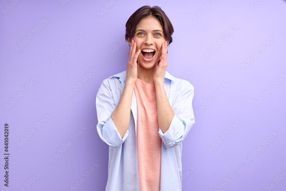 Young female with short hair scream by happiness, caucasian woman in casual shirt surprised by something. isolated purple background Young female with short hair scream by happiness, caucasian woman in casual shirt surprised by something. isolated purple background