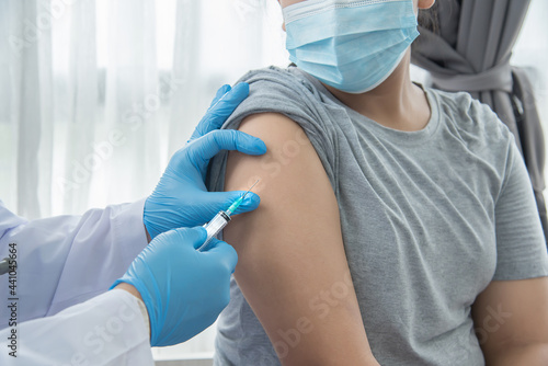 Doctor injection virus vaccine Corona to asian woman