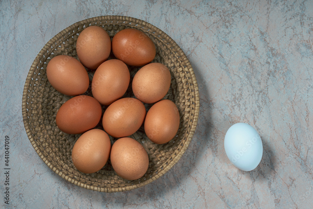 several fresh chicken eggs in a straw basket on a wooden background. Healthy eating concept. several fresh chicken eggs in a straw basket on a wooden background. Healthy eating concept.