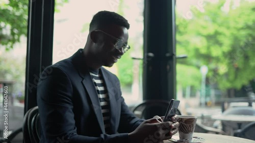 Young businessman text messaging at the coffee break.