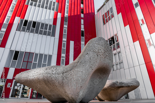 Avant-garde stone benches, in front of a modern building, with straight lines and red and gray color.  photo