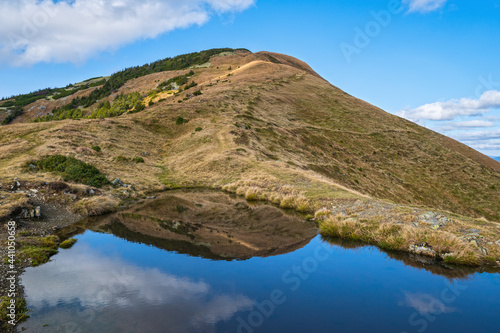 Small picturesque lake with clouds reflections at the  Strymba Mount. Beautiful autumn day in Carpathian Mountains near Kolochava village, Transcarpathia, Ukraine. photo