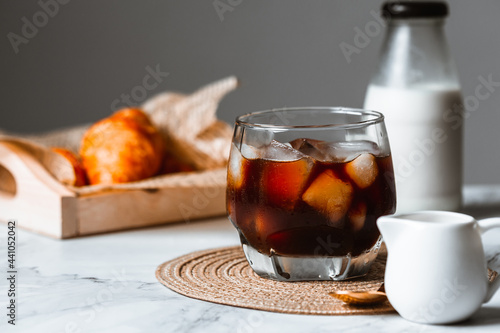iced cold brew coffee with bakery and milk background on white marble table