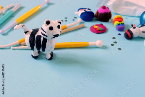 making a figurine of a white tiger from plasticine intermediate stage step by step, final work. © Olga