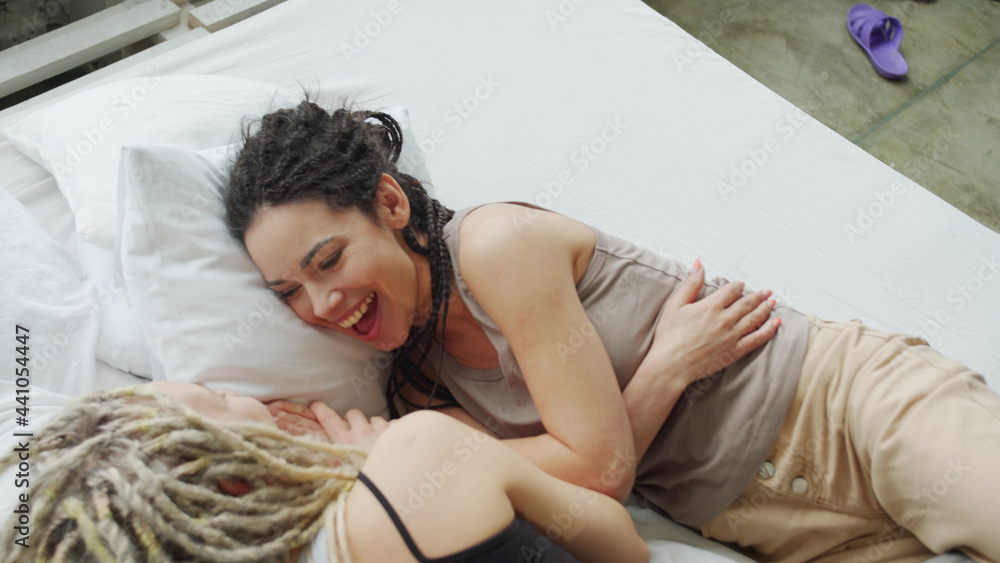 Naklejka premium Young couple chatting and cuddling in bed at home in bedroom