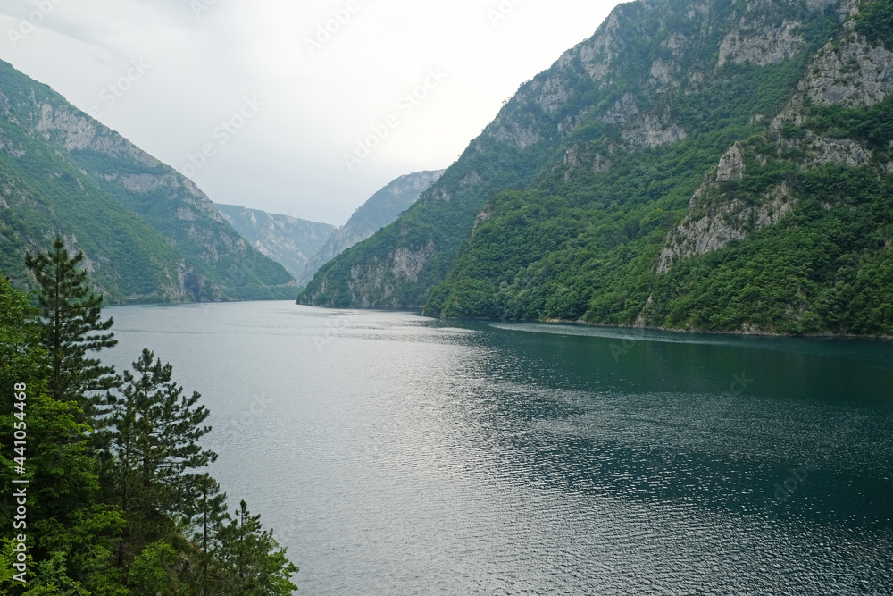 Mountain landscape of green Piva lake in a summer rainy day