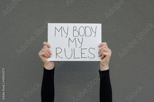 Obraz na plátne Female hands holding a protest sign with the claim My Body My Rules