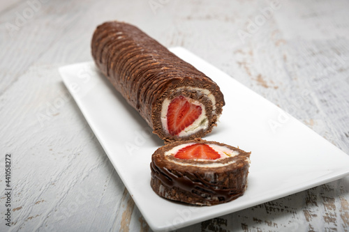 Homemade cake roll with chocolate and fresh strawberry