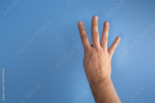 hand on blue screen making number 4