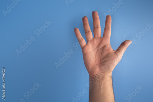hand on blue screen making number 5