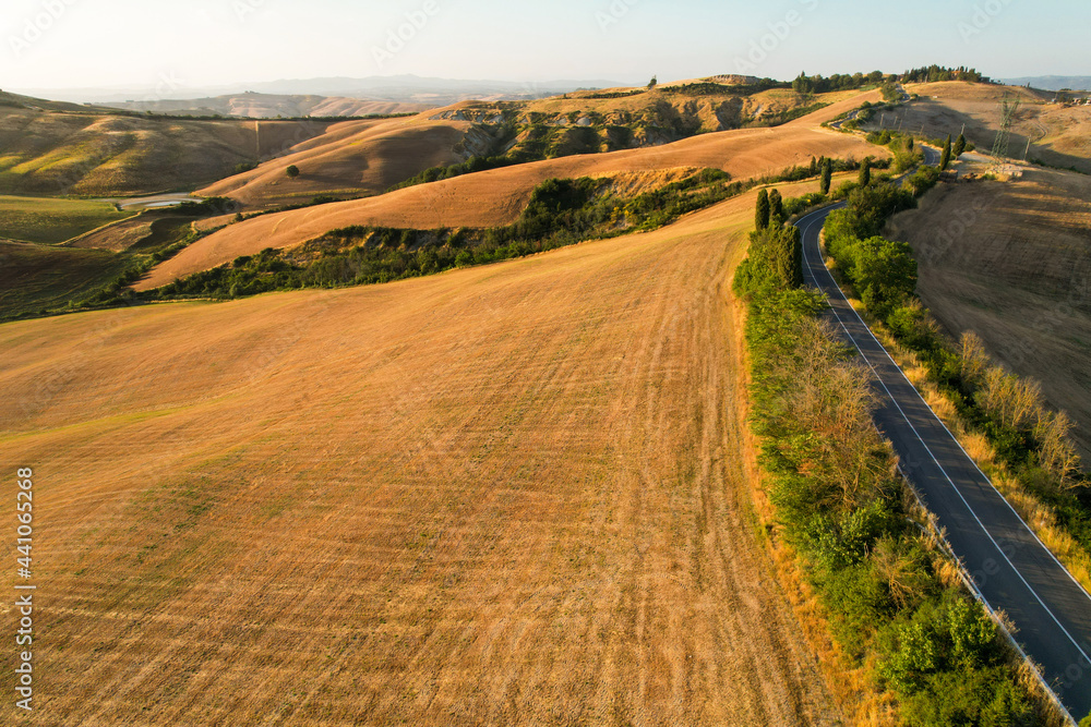 Beautiful idyllic summer landscape of Toscana with many mediterranean plants, hills, trees and fields. Sunny evening or morning in Italy. Vacation, recreation mood. Agricultural fields of Tuscany 