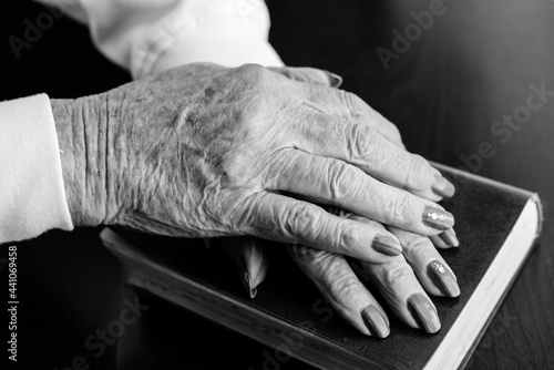 Aged hands placed on a book.