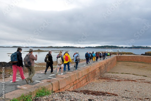 Group of people walking on the dike for boarding in the brehat island boats