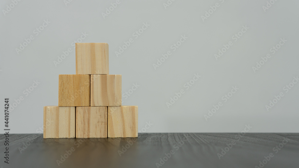 The wooden cubes are arranged in the shape of a pyramid on a white background table and can be put on your own message. business idea, The wooden cubes are arranged in the shape of a pyramid on a white background table and can be put on your own message. business idea,