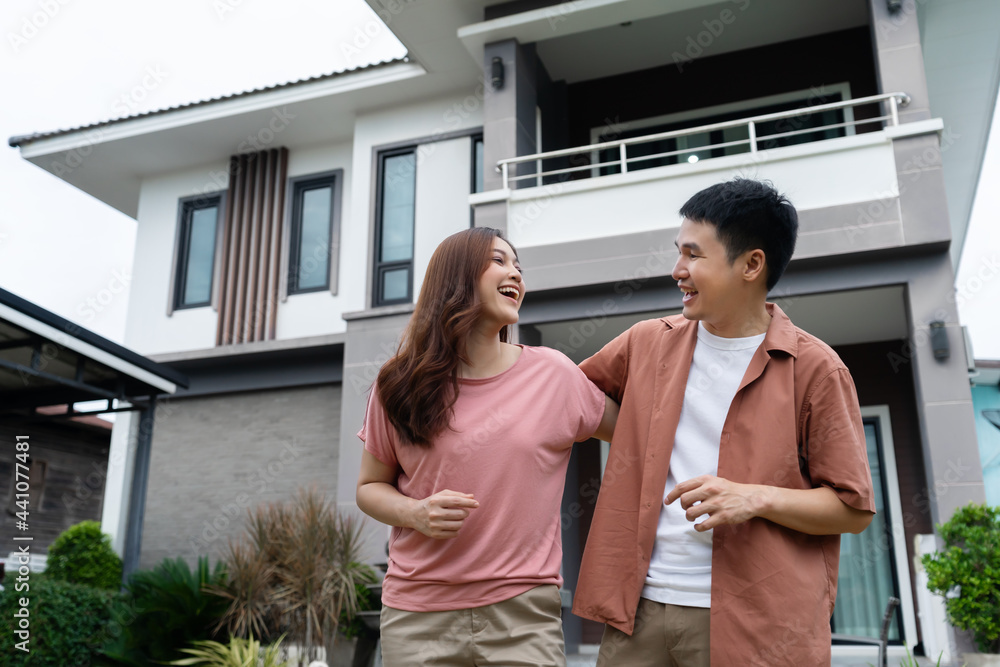 Fototapeta premium cheerful couple standing outside their house