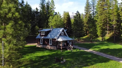 HD 4k drone footage of a cabin in montana with beautiful tall snow peaked mountains in the background near Glacier National Park