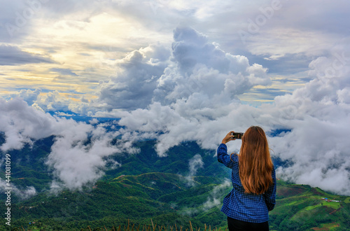 Young girl stand on viewpoint with white cloud and sunset sky at border of Thailand and Myanmar, Chiang Rai province norther of Thailand