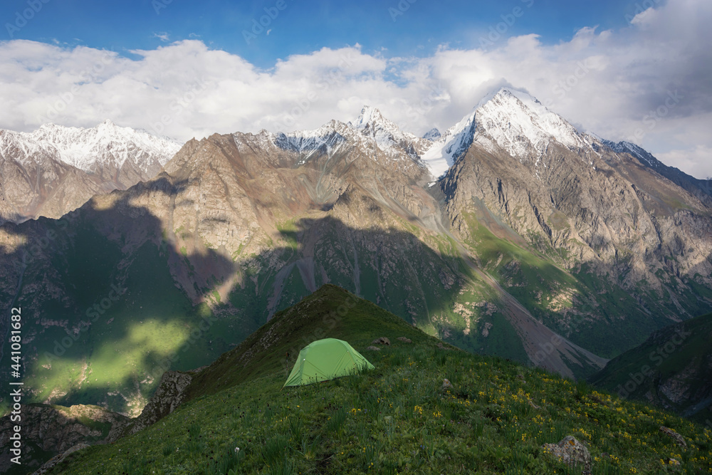 Mountain landscape view in Kyrgyzstan. Rocks, snow and tent in mountain valley view. Mountain panorama.