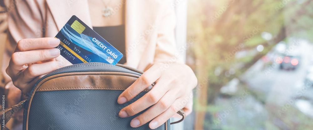 Woman takes a credit card out of her pocket to make a purchase.