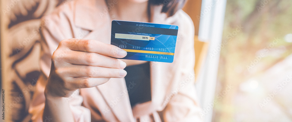 Woman takes a credit card out of her pocket to make a purchase.