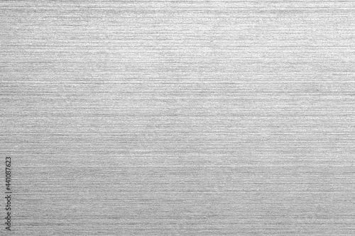 Shiny silver polished metal background texture of brushed stainless steel plate with the reflection of light.