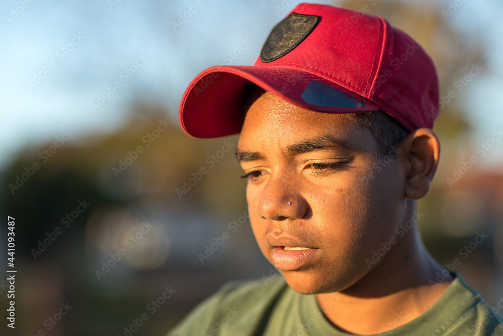 head and shoulders of teen boy wearing red baseball cap head and shoulders of teen boy wearing red baseball cap