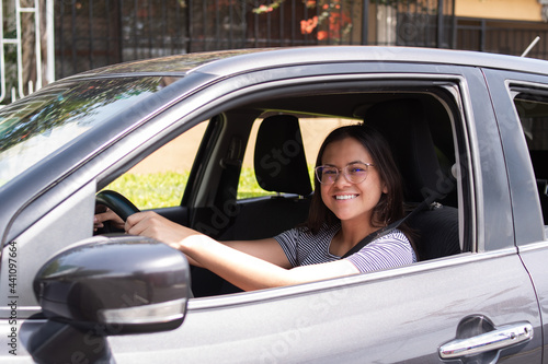 Very smiling young woman driving her new car © Roy