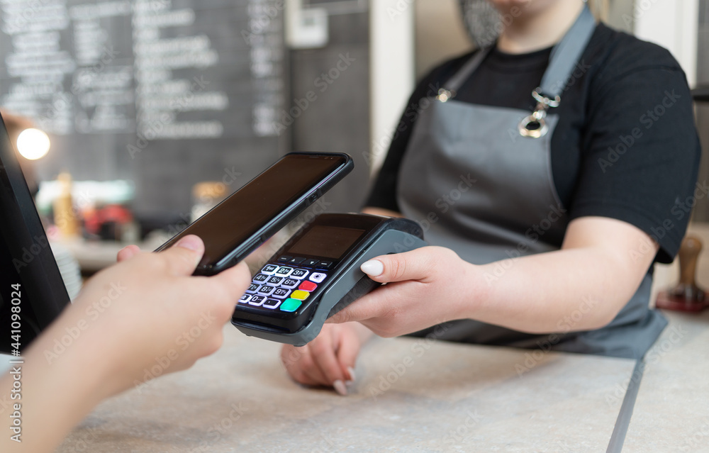 custom made wallpaper toronto digitalA woman pays with a phone with NFS technology on the phone with a contactless terminal in a cafe shop or cafeteria. Mobile phone for order payment with nfs technology.