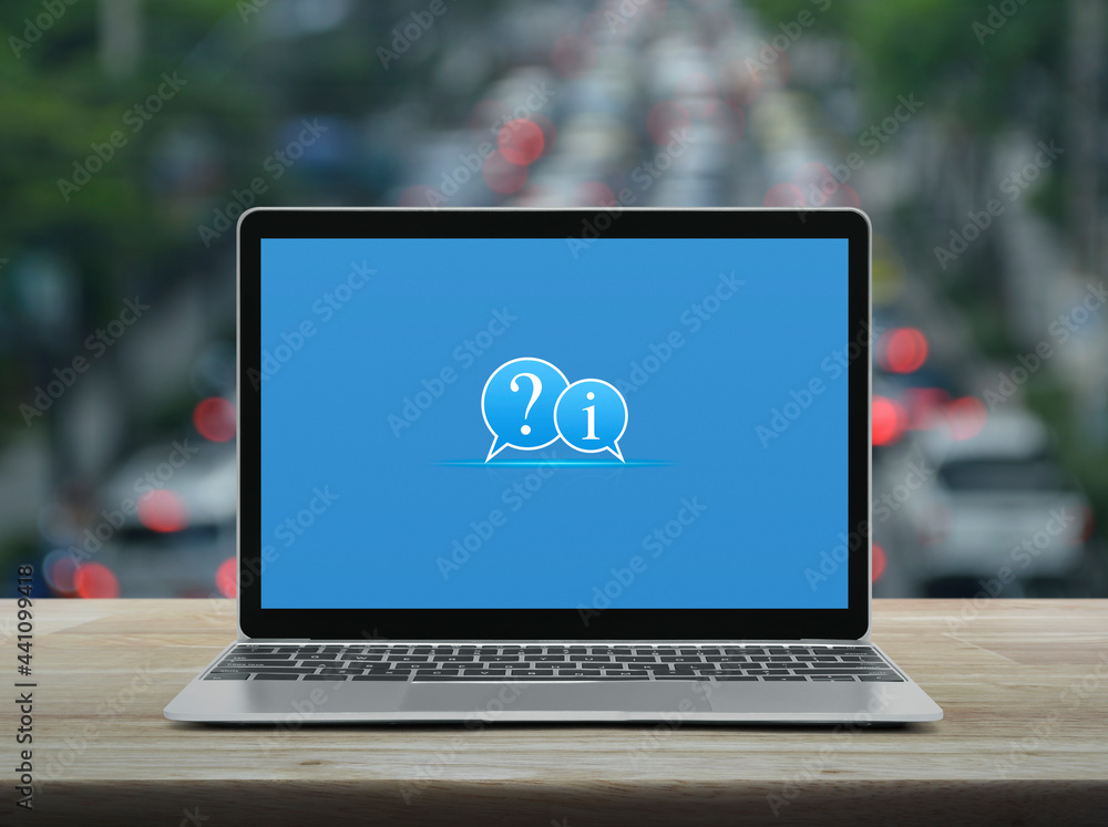 Question mark and information chat icon with modern laptop computer on wooden table over blur of rush hour with cars and road in city, Business customer service and support online concept Question mark and information chat icon with modern laptop computer on wooden table over blur of rush hour with cars and road in city, Business customer service and support online concept