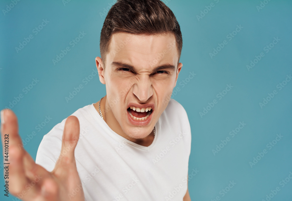 emotional man in a white t-shirt gesturing with his hands emotions close-up blue background emotional man in a white t-shirt gesturing with his hands emotions close-up blue background