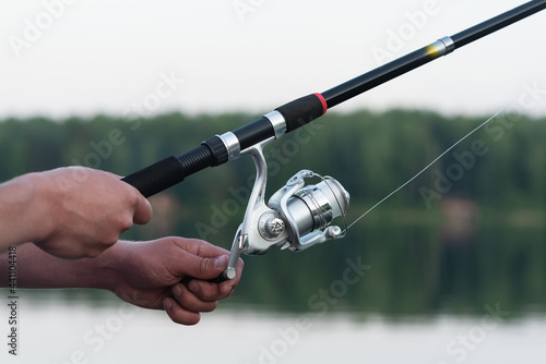 Fishing rod in the hands of fisherman background. Fishing concept background.