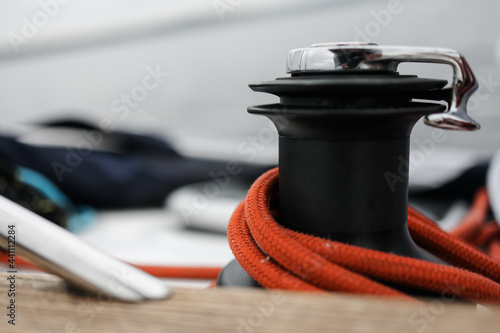 Boat trip on the river. Details about the sailing yacht. In the summer, we go by boat. A white yacht with full sails. Leisure, sports, recreation theme. Close-up view of a reel with a rope. Attachment © Anna