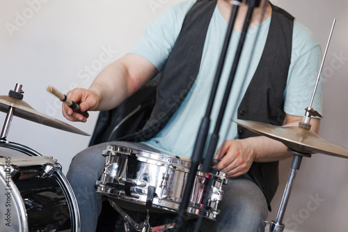 Drummer plays on a snare drum and cymbals