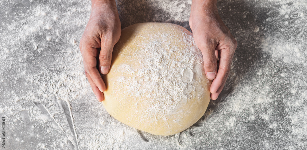 The chef is kneading the dough to make fresh bread on the kitchen table. The chef is kneading the dough to make fresh bread on the kitchen table.