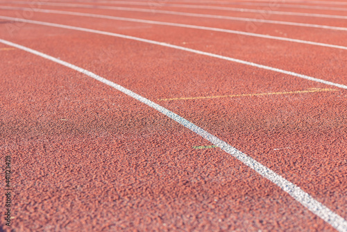 Part Red plastic track in the outdoor track and field stadium.Close-up. © ARVD73