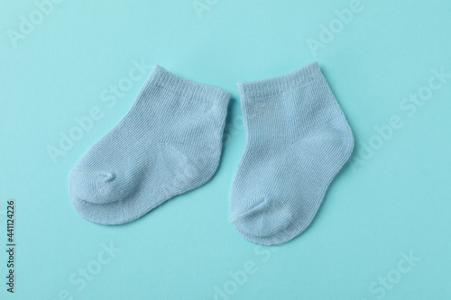 Pair of cute baby socks on blue background