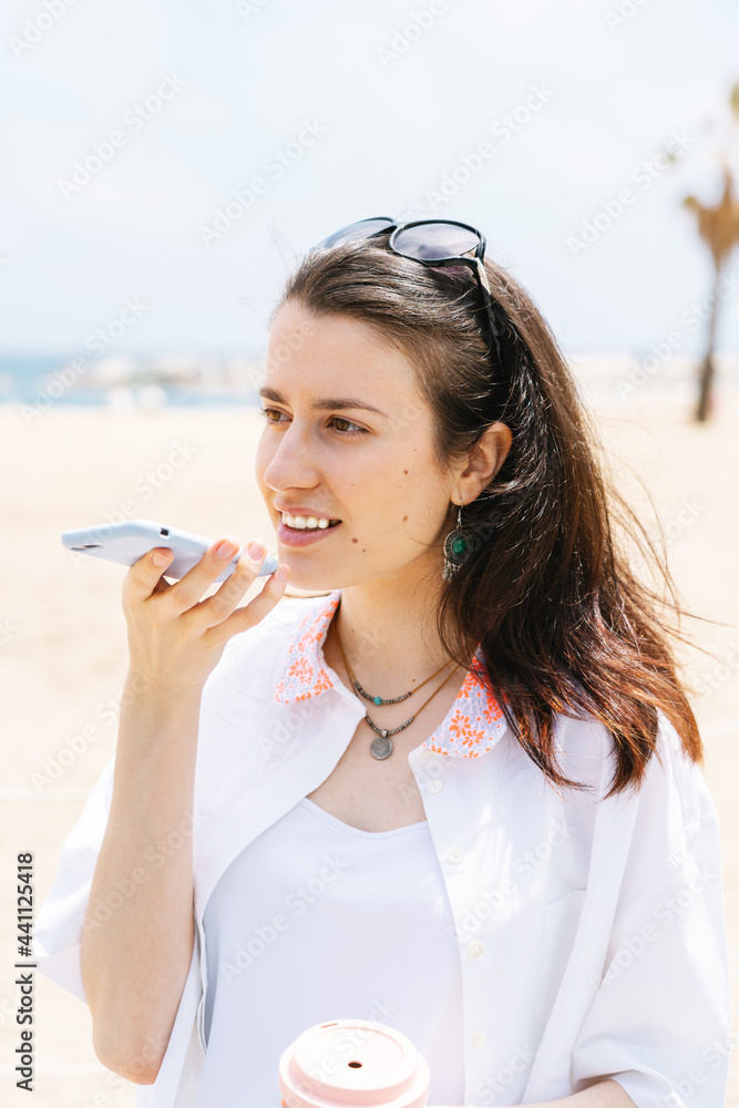 girl recording a voice message with the mobile on the beach girl recording a voice message with the mobile on the beach