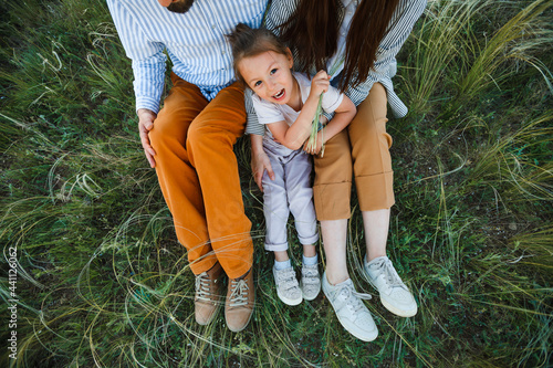 A hipster family walks in a summer field.