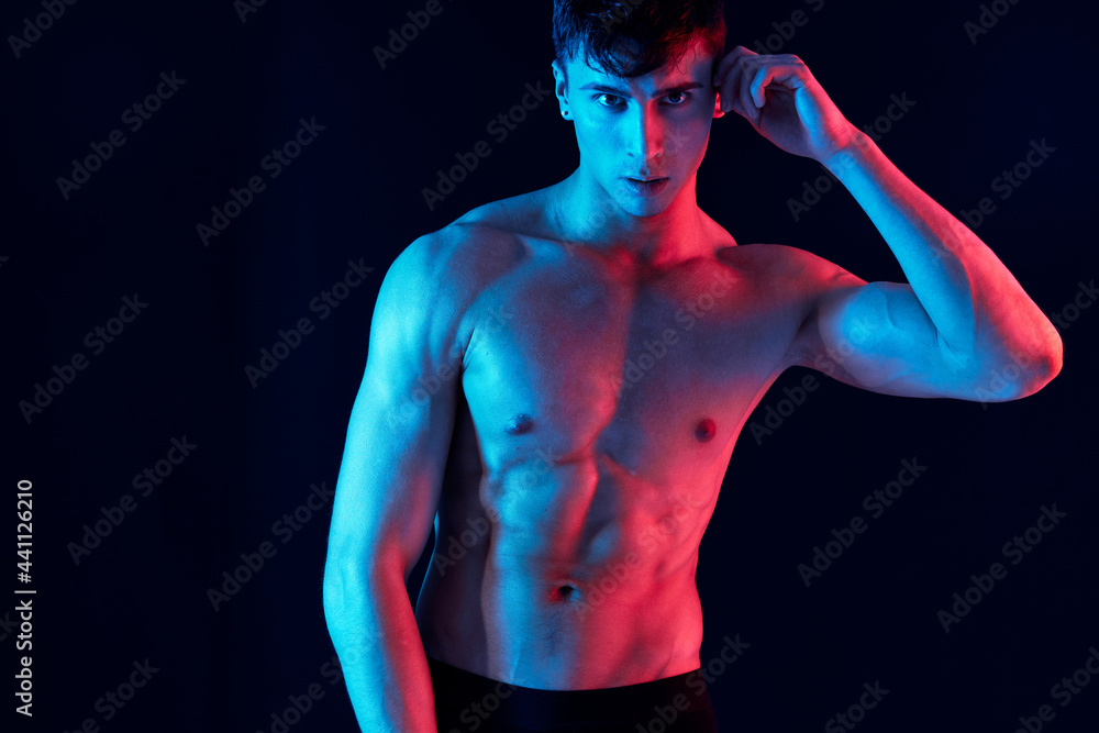 male athlete gesturing with his hands on a black background and neon skin color 